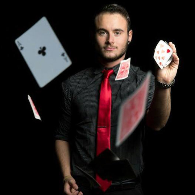 Magician with cards floating in front of him.