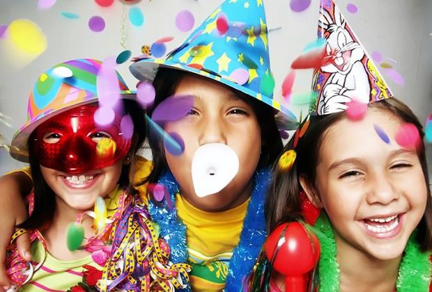 Three girls wearing party hats with confetti falling from above.