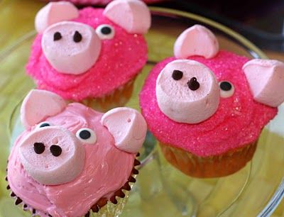 Three cupcakes decorated to look like pigs.