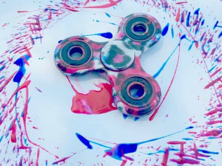 A fidget spinner surrounded by a circle of paint.