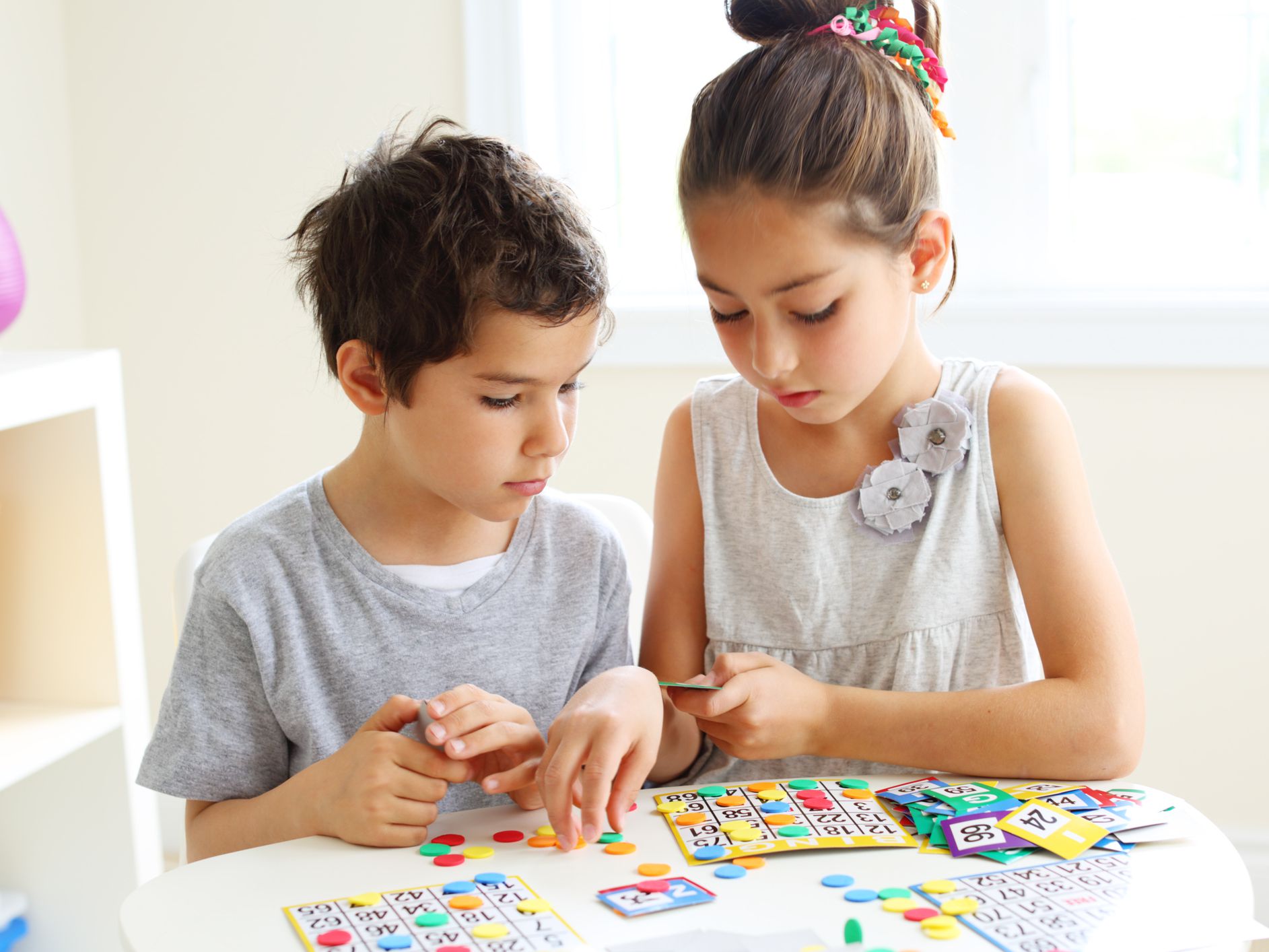A boy and a girl playing bingo.
