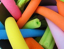 Pile of colorful pool noodles.