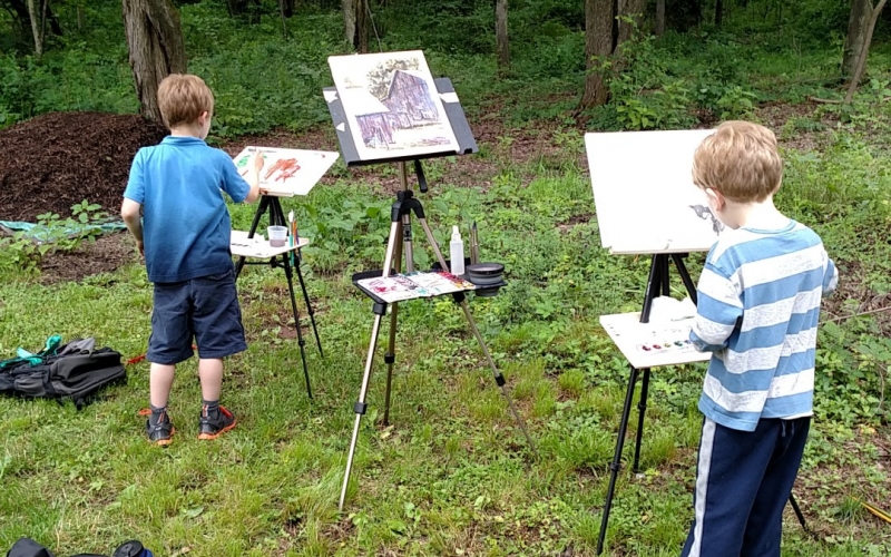 Two boys painting outside