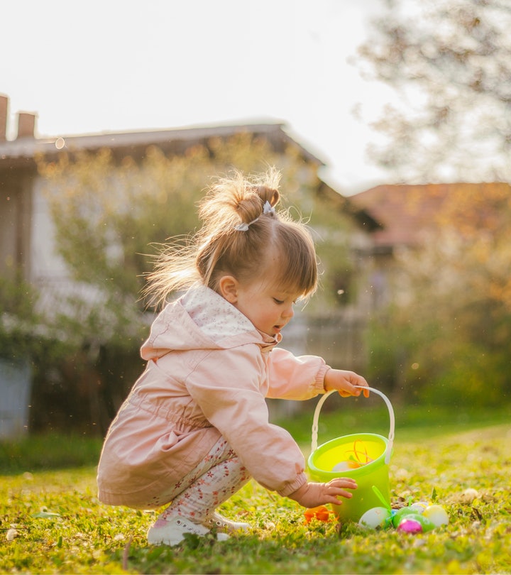 Young girl with an basket, picking up a plastic egg.