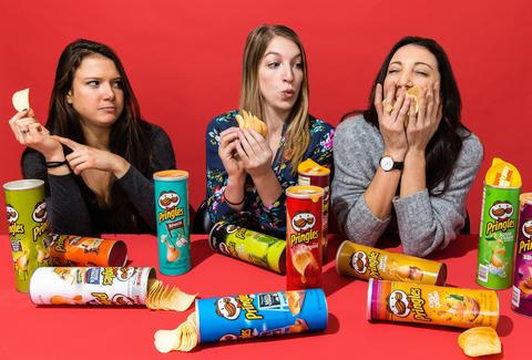 Three young women eating different flavored Pringles.