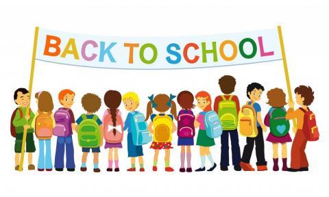 Several children standing under a banner that reads, "Back to School."