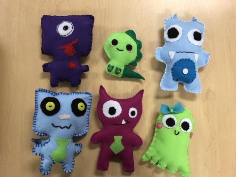 Six hand-sewn felt monsters.