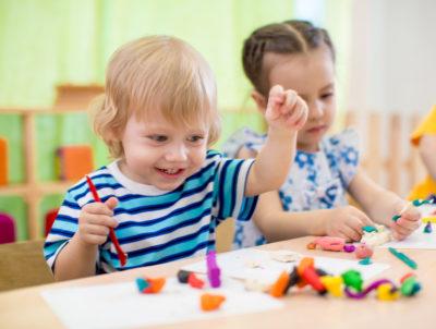 Two young children playing with playdough.