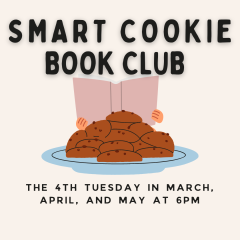 A child reading a book behind a plate of cookies