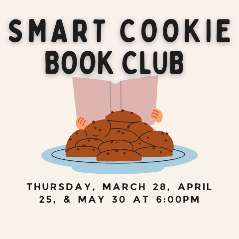 A child reading a book behind a plate of cookies