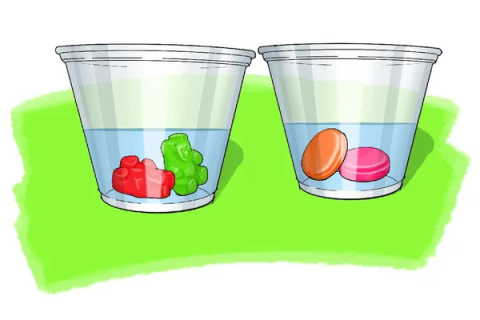 Two plastic cups with water and candy inside