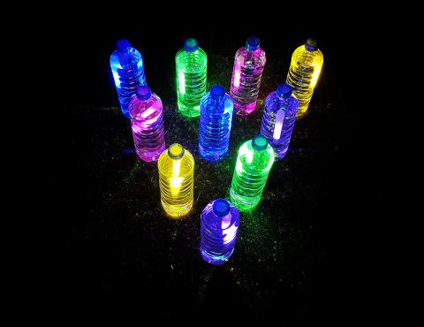 Plastic water bottles filled with water and glow sticks.