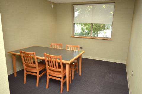 Room with a window, one table, and four chairs