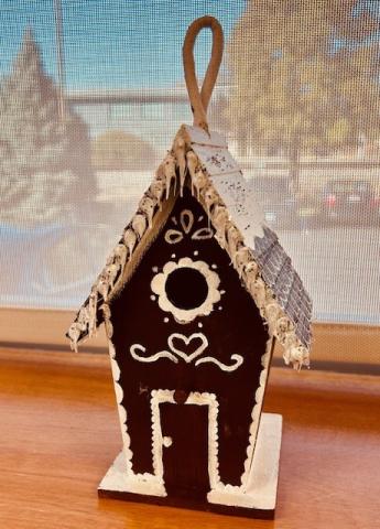 a birdhouse painted in the style of a gingerbread house