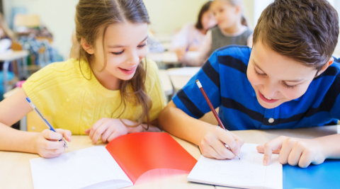 Two children writing.