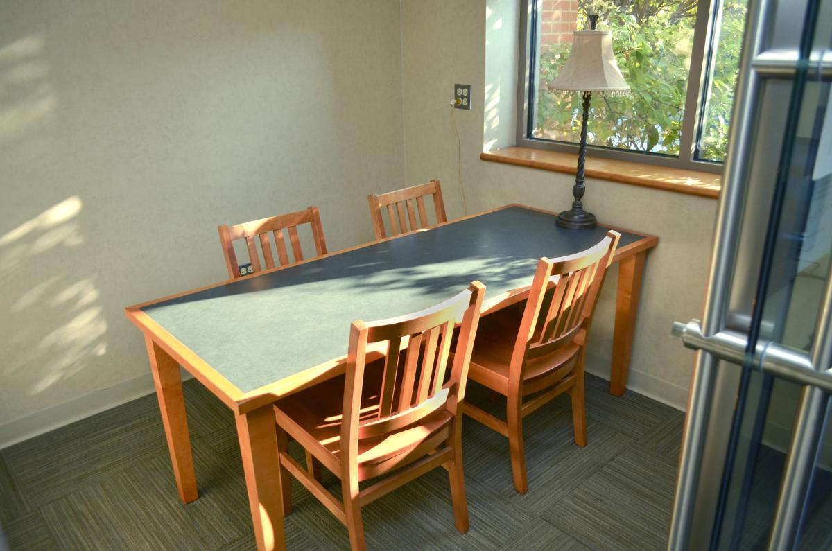 Room with a window, one table, and four chairs