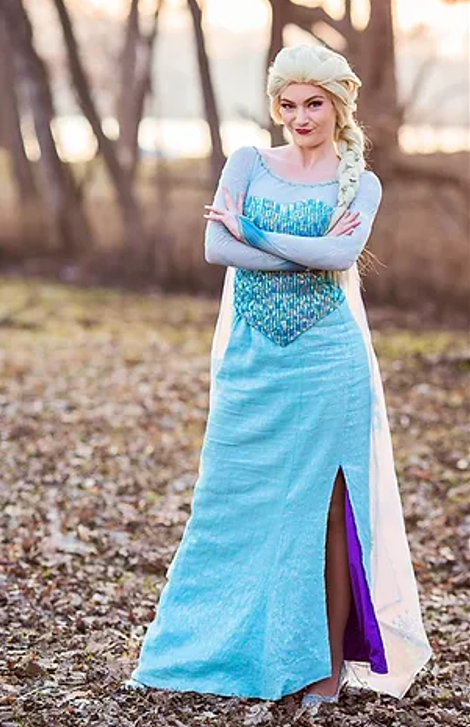 Woman with a long, light-blonde braid, standing with her arms folded in a sparkly gown.