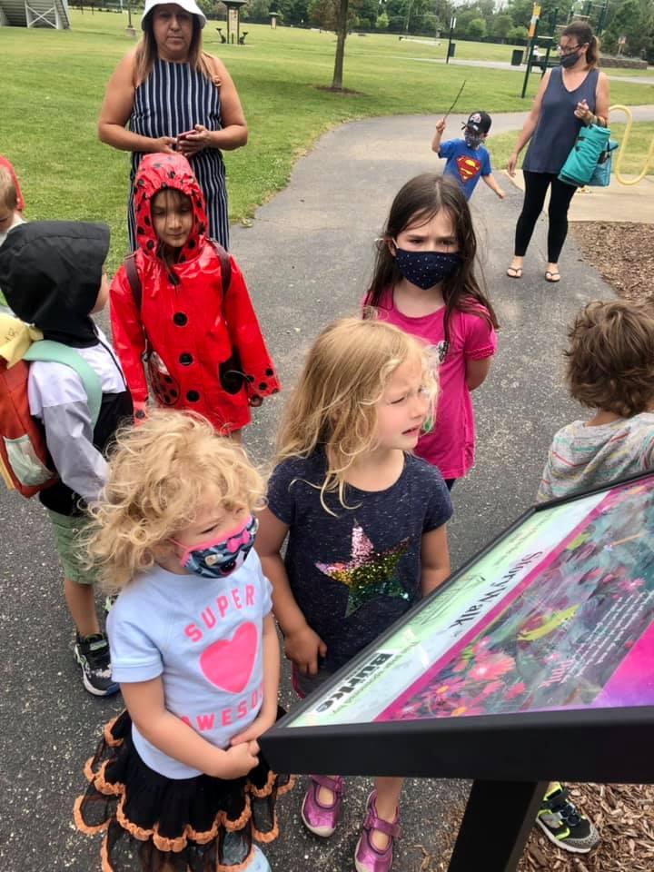 Children looking at a page of the Storywalk at a park.
